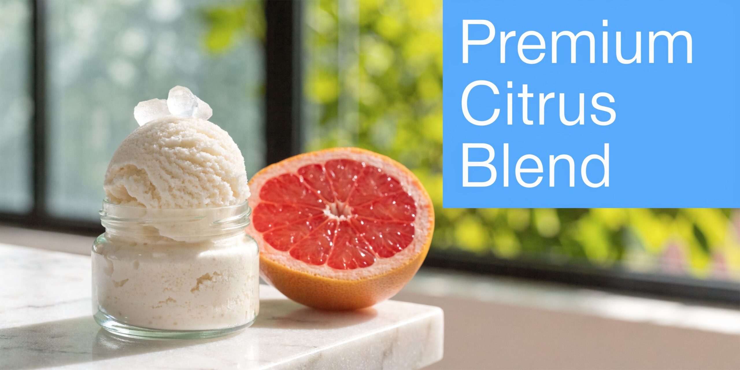 A scoop of premium white grapefruit gelato in a small glass jar next to a halved grapefruit.