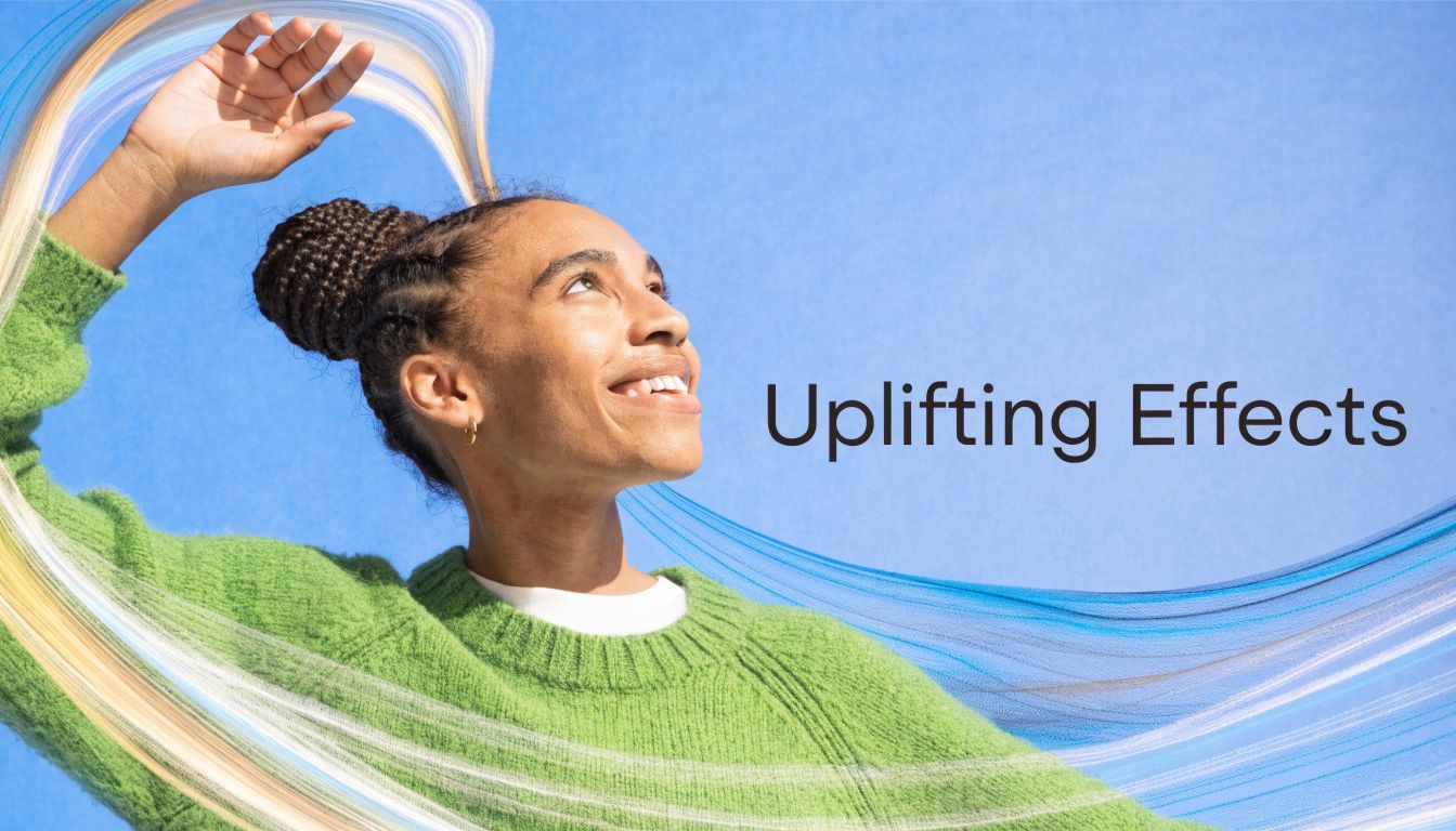 A smiling person in a green sweater looking upwards with abstract blue and gold light streaks.