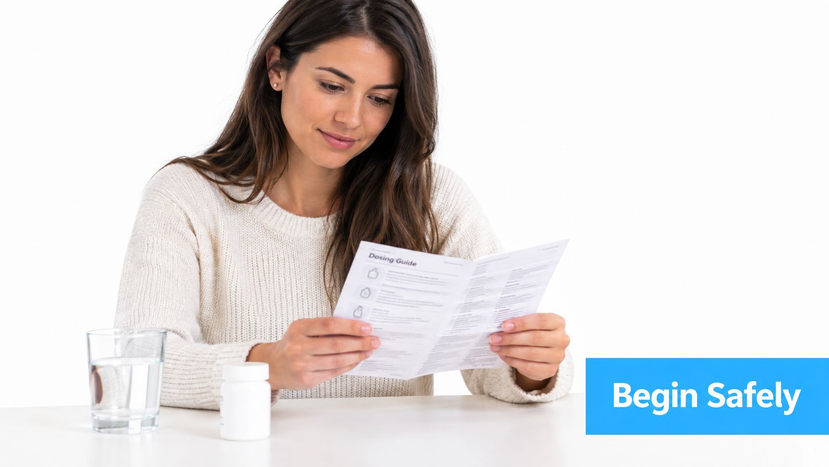 A young woman in a sweater reading a medication dosing guide with a glass of water nearby.